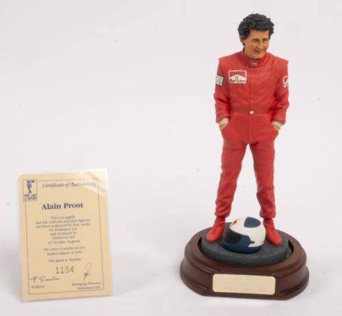 ALAIN PROST: A 1:9 scale limited edition (1154/5000) cold cast porcelain resin figure of Alain Prost sculpted by Paul Szeiler for Endurance Ltd, on wooden base with engraved plaque, NIB and accompanied by a COA from The Art of Sport, 22cm high