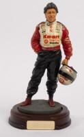 MARIO ANDRETTI: A 1:9 scale limited edition&nbsp;cold cast porcelain resin figure of Mario Andretti&nbsp;sculpted by Paul Szeiler for Endurance Ltd, on wooden base with engraved plaque,&nbsp;22cm high