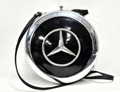 A decorative lined ladies handbag constructed from two Mercedes-Benz hubcaps, 25cm diameter, by automotive artist Terry Lawrie