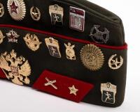 USSR: A Soviet Military styled Garrison hat, green with red piping. Fitted with various Soviet era pins. - 2
