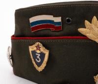 USSR: A Soviet Military styled Garrison hat, green with red piping. Fitted with various Soviet era pins. - 2
