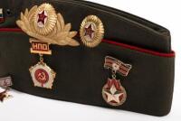 USSR: A Soviet Military styled Garrison hat, green with red piping. Fitted with various Soviet era pins. - 3