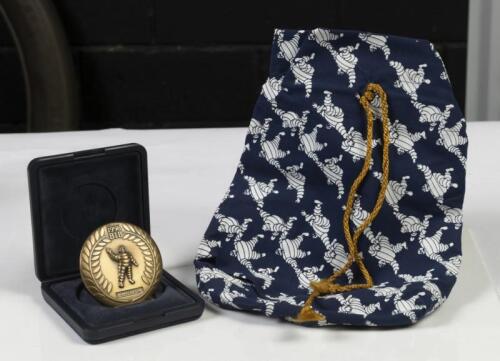 MICHELIN: Two Michelin related items, comprising&nbsp;a 1998 Commemorative coin with Bibendum on&nbsp;front and&nbsp;rear, in presentation box and a small Michelin satchel bag