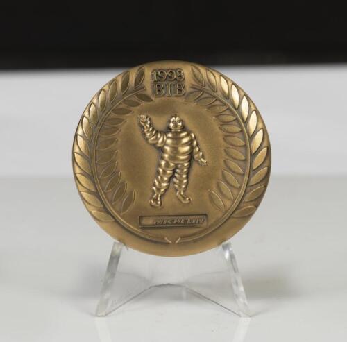 MICHELIN: A commemorative double sided coin celebrating 100 years of Michelin, 1898-1988, 6.5cm wide, with stand