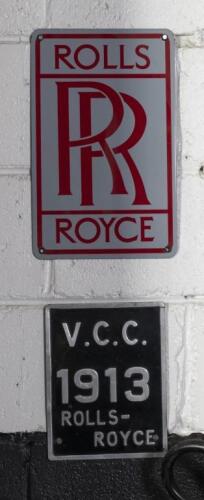 ROLLS ROYCE: Two Rolls Royce related items comprising a&nbsp;small reproduction enamel Rolls Royce sign and a tin 'V.C.C' 1913 Rolls Royce' plaque, largest 30.5cm high, 19cm wide.