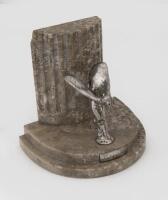 ROLLS-ROYCE: A Rolls-Royce book end with 'Spirit of Ecstasy' mounted emblem, base is marble with fluted columns at rear, mascot engraved 'S&SLTD (Saunders & Shepherd, London)', silver plaque at front reads 'G.N.C.M'