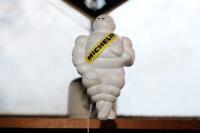 MICHELIN: A modern plastic seated Michelin Bibendum figure with bracket, approx 22cm high - 2