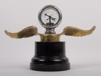 CAR MASCOT: A pre-war brass winged mascot with Calorimeter&nbsp;(temperature gauge) at centre, made by Wilmot of Birmingham, affixed to bakelite base