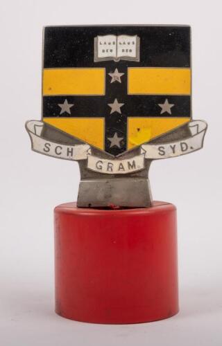 SYDNEY GRAMMAR: An early enamel Sydney Grammar School badge made by Angus & Coote Sydney affixed to plastic base, 9cm high (badge only), 9.5cm wide