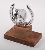 EQUESTRIAN: A chrome horse bust in horseshoe mascot affixed to wooden base, 8cm high (mascot only)