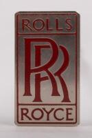 ROLLS-ROYCE: A Rolls-Royce radiator emblem badge, red 'RR'&nbsp;lettering on chrome&nbsp;background, 7cm high, 4cm wide