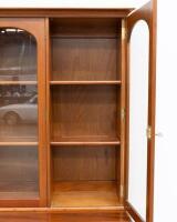 BOOK CASE: A two tiered timber bookcase by Pfitzner Furniture South Australia, featuring glazed display cabinetry, with a drawer and storage space to the lower, 137cm wide, 207cm high, 47cm deep - 19