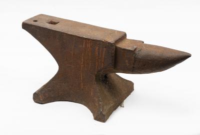 ANVIL: A large cast-iron metal anvil. Measures 25.5 cm high, 60 cm wide