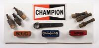 DISPLAY BOARD: A display board consisting of a Champion spark plug sticker, several spark plugs and early tin spark plug containers plus one wrench, 21cm high, 48cm wide