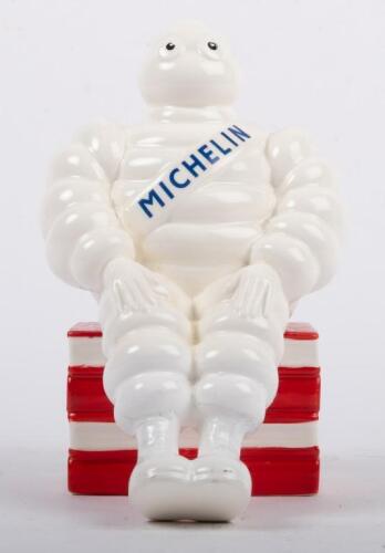 MICHELIN: A ceramic Michelin money box featuring Bibendum seated to a stack of books, approx 18cm high
