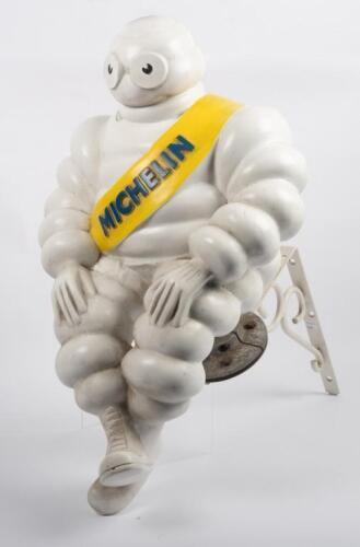 91 · MICHELIN: A large seated Michelin Bibendum figure on base, with modern hanging bracket, Figure approximately 59cm high