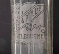 SODA SYPHONS: Two glass soda syphons, one etched 'Boon Spa Pty Ltd Melbourne', the other with netting, unmarked, largest 33cm high - 2