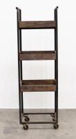 STORAGE TROLLEY: A tall metal framed storage trolley on castor wheels with light timber trays, 165cm high, 54cm wide, 37cm deep