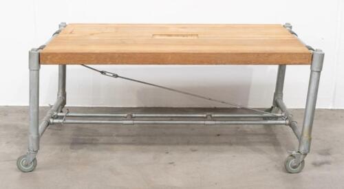 INDUSTRIAL TABLE: A heavy industrial table, with a solid timber top with a hole cut out possibly for mounting of machinery or a tool, measures approximately 78cm high, 176cm wide, 102cm deep overall
