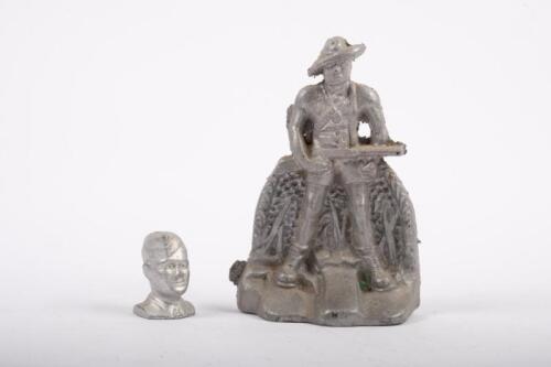 CAST FIGURES: Two cast aluminium figures, one of a WW2 soilder 15cm high, the other a head of a figure believed to be Navy 5cm high