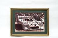 PORSCHE 917/30: A large circa mid 1980s framed photograph of Alan Hamilton sitting in a Can-Am Porsche 917/30, signed by Hamilton staff