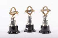 TROPHIES: Three trophies, all not inscribed, all have wreath and racing car finials with round bakelite bases
