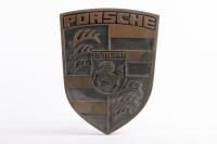 DOOR HANDLE: A solid brass double-sided Porsche emblem door handle from entrance glass door at former Hamilton Porsche dealership at Bryant & May building in Cremorne, 26cm high, 21cm wide
