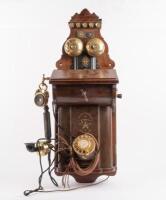 ERICSSON WALL PHONE: An early 20th Century restored antique Ericsson wall phone, oak case with sloped front, twin brass bells and dial and crank handle, with Ericsson Stockholm trademark