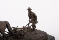 PLOWMAN: A fine late 19th / early 20th Century bronze figure of a farmer ploughing the land, this was a gift from Alan to Norman represent his thanks for Norman for sowing the seeds of Porsche for him, 28cm long - 4
