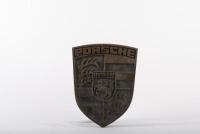 DOOR HANDLE: A solid brass double-sided Porsche emblem door handle from entrance glass door at former Hamilton Porsche dealership at Bryant & May building in Cremorne