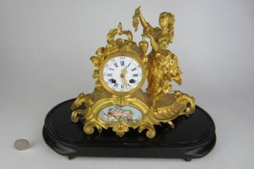 CLOCK: A late 19th century French porcelain panelled gilt metal mantle clock