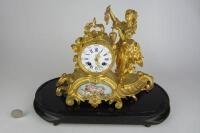 CLOCK: A late 19th century French porcelain panelled gilt metal mantle clock