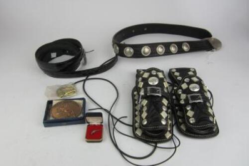 FIREARMS: A collection of ornate black leather belts and holsters with applied medallions