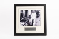 BT19: A b/w photograph featuring Sir Jack in a European pits with his BT19, hand signed by Sir Jack, image 19cm high, 25.5cm wide