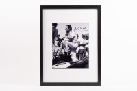 JACK BRABHAM: A b/w photograph featuring Sir Jack conversing in pits, hand signed by Sir Jack in black marker, mounted, framed and glazed, image 24.5cm high, 19.5cm wide