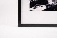 JACK BRABHAM: A b/w photograph featuring Sir Jack conversing in pits, hand signed by Sir Jack in black marker, mounted, framed and glazed, image 24.5cm high, 19.5cm wide - 3