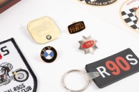 MOTORCYCLE TRINKETS: A small group of motorcycle related trinkets, including a Vincent HRD badge, a BSA badge, a group of BMW items, American Historic Racing Motorcycle Association stickers, all stored within modern timber 'Motorcycle Club' box. - 2
