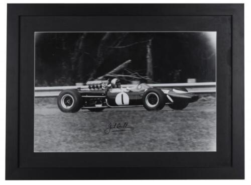 BRABHAM: A signed black and white print of Sir Jack Brabham driving a Brabham BT19. Sir Jack Brabham signature