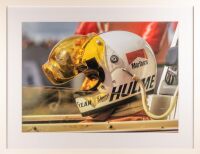 HULME: A striking large colour photograph of Denny Hulme in his Marlboro Team Texaco-sponsored McLaren M23 in 1974 with rain visored helmet, 81.5cm high, 105.5 wide overall