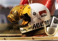HULME: A striking large colour photograph of Denny Hulme in his Marlboro Team Texaco-sponsored McLaren M23 in 1974 with rain visored helmet, 81.5cm high, 105.5 wide overall - 2