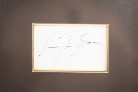 SENNA: A framed collage containing a print after the original airbrush painting by G.Willem Lubach titled 'Ayrton Senna - JPS Lotus 98T "86" along with Ayrton Senna signature on card mounted within frame. Measures 38.5cm high, 62.5cm wide - 4