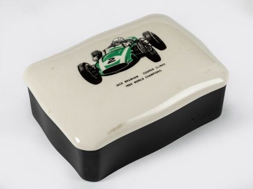 BRABHAM: A ceramic trinket box produced for the 1961 Racing Car Show, features Jack Brabham's Cooper Climax #2 to lid, measures approx 13.5cm wide