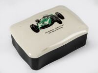 BRABHAM: A ceramic trinket box produced for the 1961 Racing Car Show, features Jack Brabham's Cooper Climax #2 to lid, measures approx 13.5cm wide