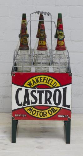 CASTROL: A 'Castrol Wakefield Motor Oil' 6 oil bottle basket stand complete with basket, 3 x Castrol embossed one imperial pint bottles, 3 x Castrol embossed one imperial quart bottles, with 5 dust caps (SALEROOM NOTICE)