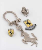 BADGES: A small group of three Ferrari badges, including an enamel 'Ferrari Owners Club' badge, along with a modern Ferrari prancing horse keyring [Location: Melbourne]