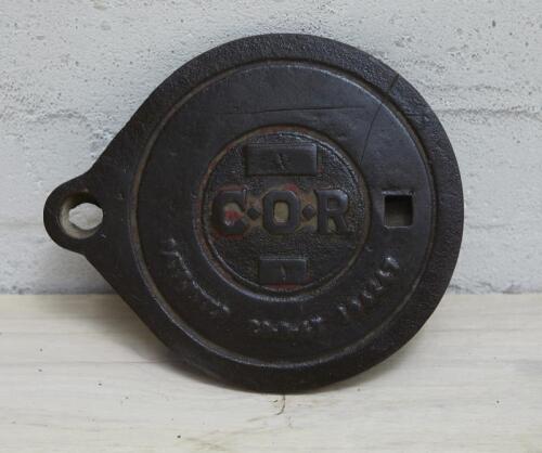 C.O.R: A cast iron service station underground tank filler cover plate with C.O.R lettering, 24x20cm.
