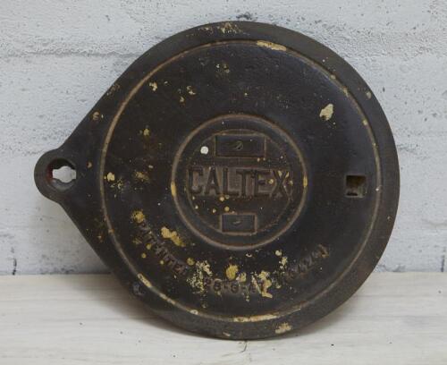 CALTEX: A cast iron service station underground tank filler cover plate with CALTEX lettering, 26cm high x 30cm wide.