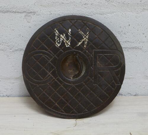 C.O.R: A cast iron service station underground tank filler cover plate with COR lettering inside cast checked pattern, 22.5cm diameter.