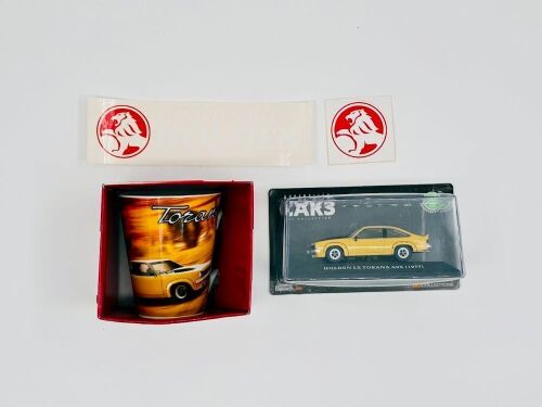 57 · HOLDEN TORANA: A 1:43 scale IXO model of the 1977 LX Torana A9X together with a ceramic Torana mug and 2 Holden stickers. [Location: Sydney]