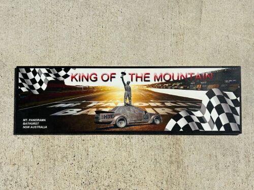 84 · KING OF THE MOUNTAIN: A metal board depicting Peter Brock at Bathurst, 100cm wide by 30cm high [Location: Sydney]